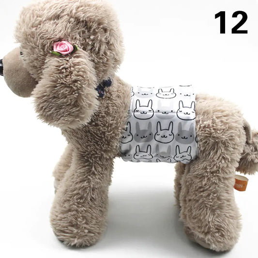 Fluffy gray plush dog with a pink flower and a patterned fabric harness on a plain white background.