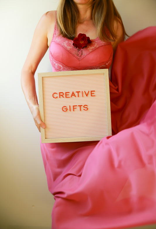 Woman holds a sign that says creative gifts.
