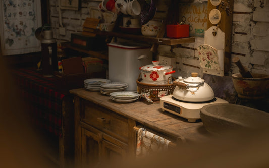 Rustic kitchen counter with kettle and dishes.