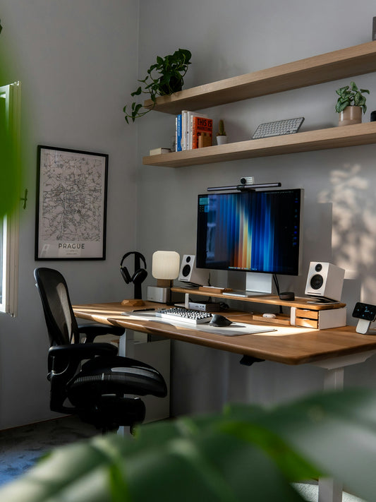 Modern home office desk setup with computer and plants.