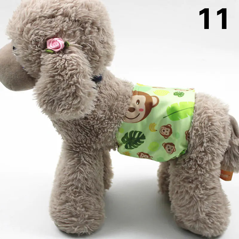 Plush gray dog toy with a pink flower and wearing a green patterned diaper or pet clothing item, displayed on a white background.
