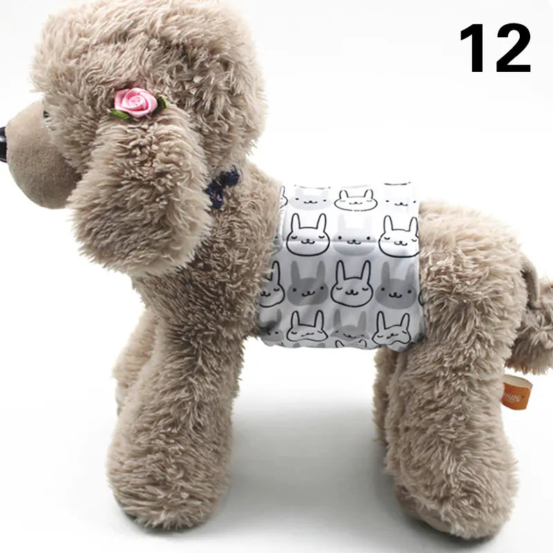 Soft and cuddly plush dog with a floral accessory, wearing a patterned fabric harness or vest with rabbit designs, positioned on a plain background.