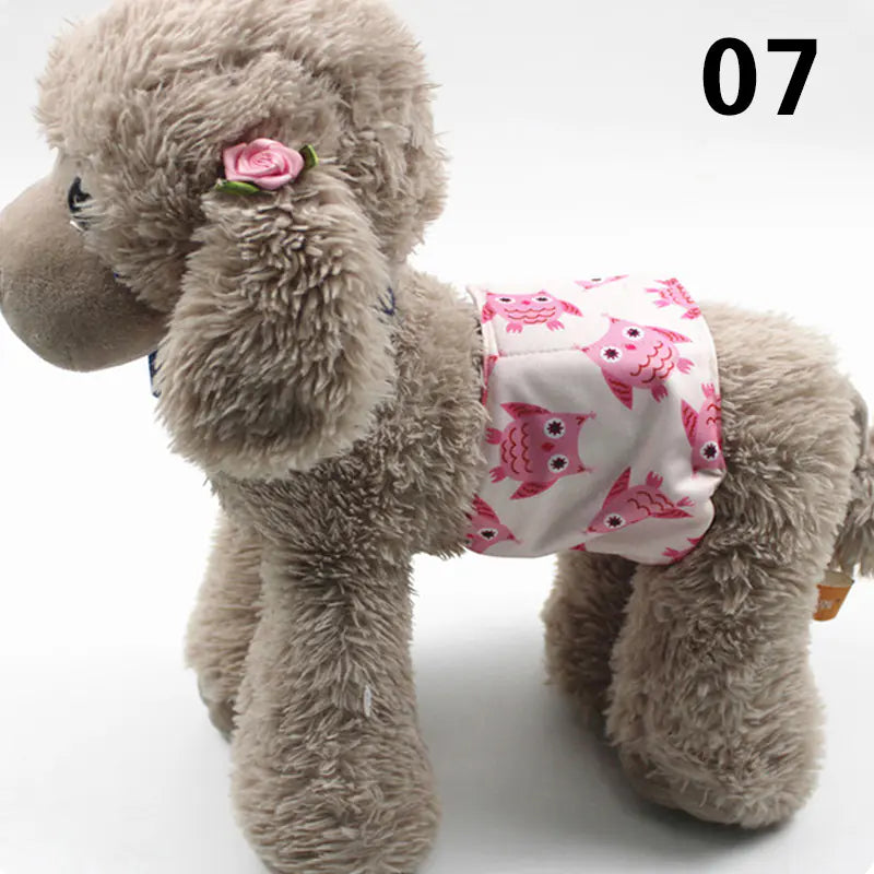 Cute gray plush toy dog wearing a pink and white printed diaper or pet pad, designed for pet care and hygiene. The toy dog has a pink flower or bow accessory attached to its head, adding a decorative touch. The product is placed on a plain background, allowing the focus to be on the absorbent pet pad and the adorable dog toy.