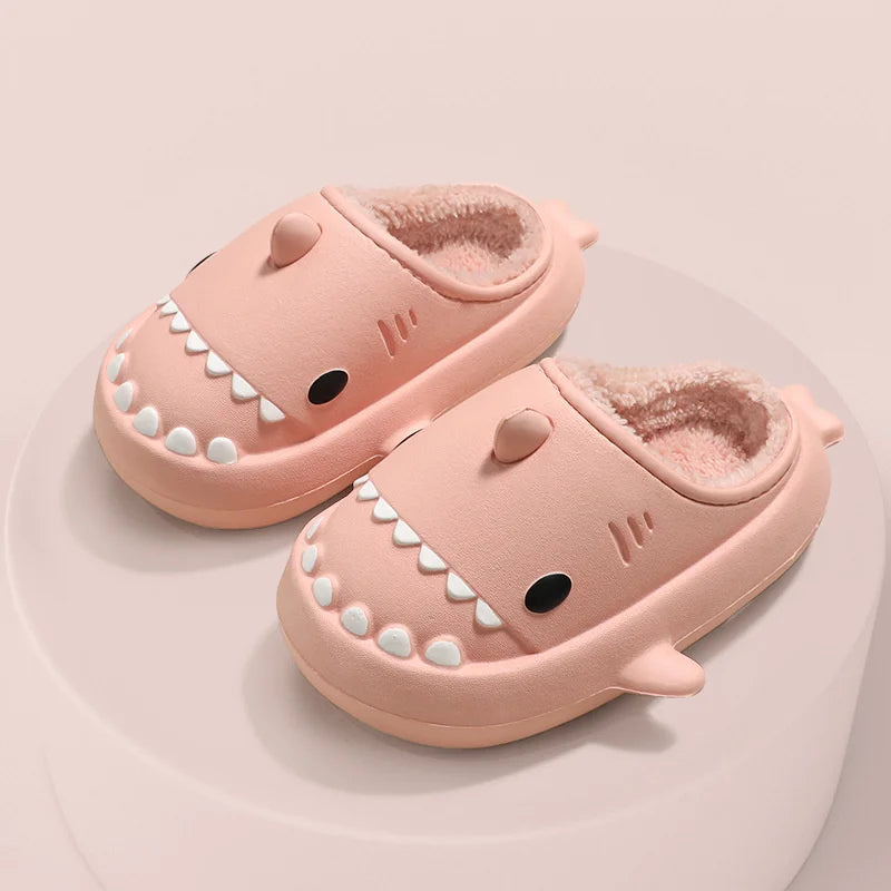 Cute kids' shark-themed plush slippers with soft faux fur lining and thick, waterproof non-slip soles, perfect for cozy indoor wear.