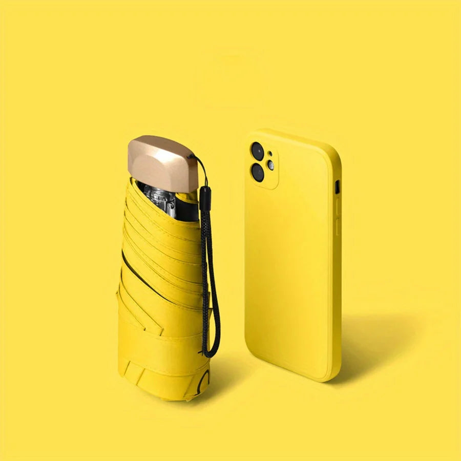 Compact UV protection umbrella and yellow smart phone on yellow background
