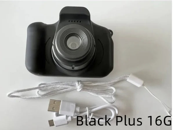 Compact kids camera with large lens for clear photos. Black camera body with USB charging cable and lanyard strap.
