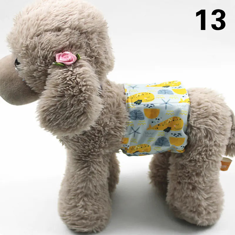 Soft and cuddly gray plush dog toy with a pink rose accent, wearing a patterned diaper or pet pad cover, on a white background.
