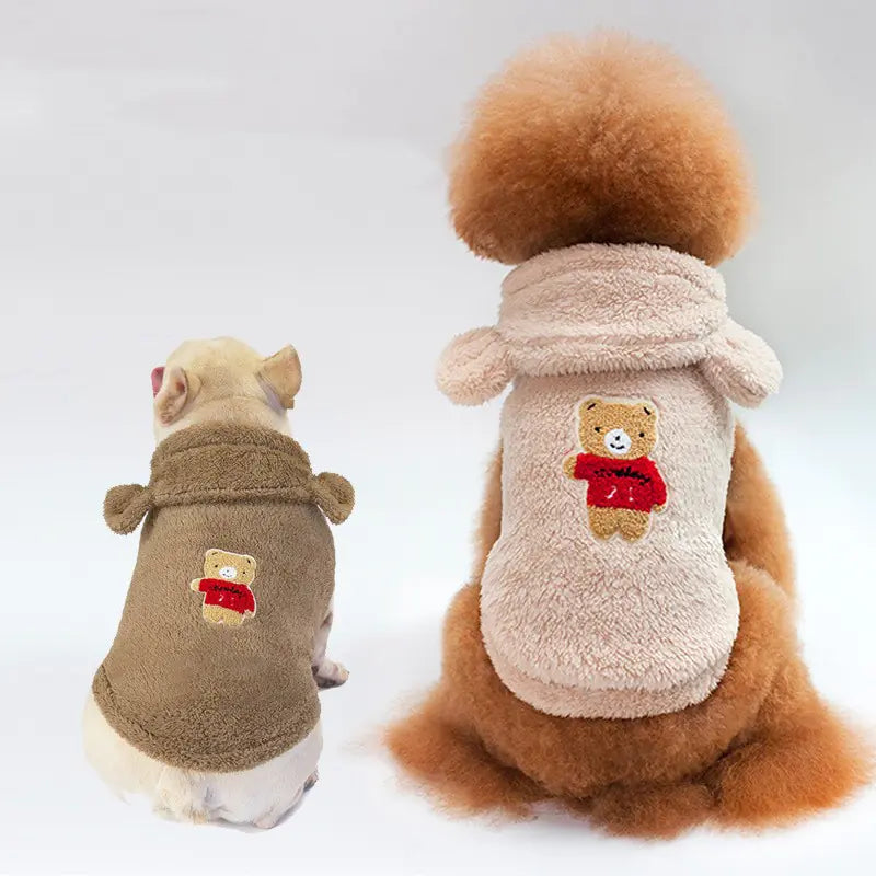 Cozy teddy bear-inspired pet hoodies in the image. The coats feature plush, furry fabric with bear ear hoods and bear graphic designs, providing a cute and warm look for the pets.